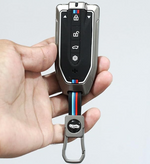 Hand holding a car key fob with BMW logo on a light gray background