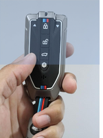 Car key fob with brand logo held in a hand against a light blue background