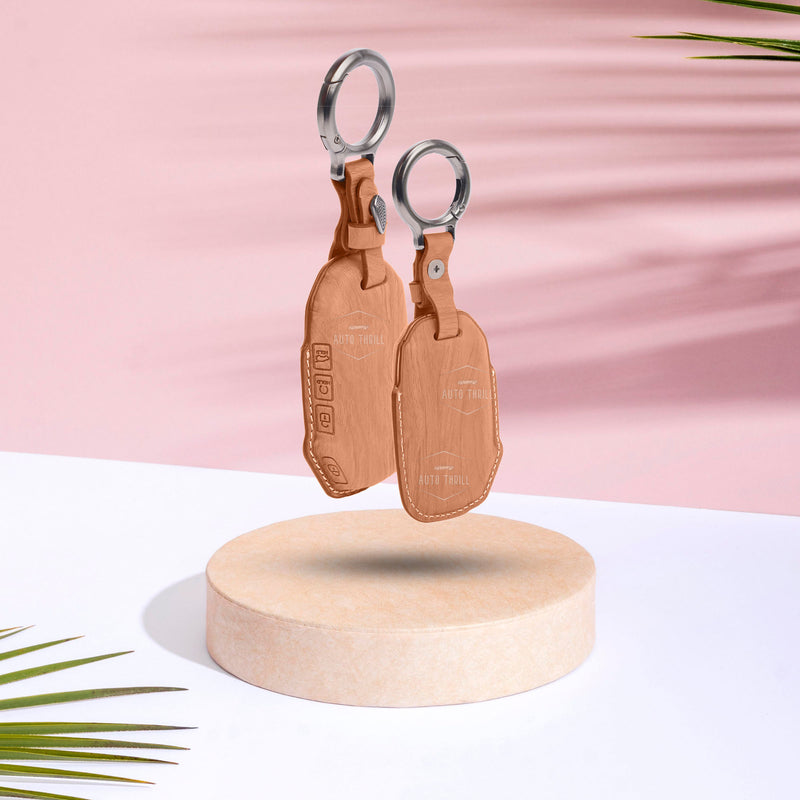 Pair of brown leather key cover on a wooden stand with a pink background