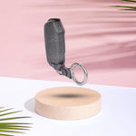 Key Cover with a clip on a wooden stand against a pink and white background