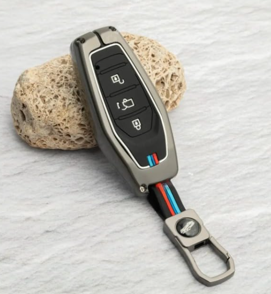 Car key fob with remote control and keychain on a textured surface