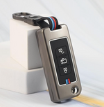 Metallic key fob with buttons on a light gray background