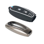 Black car key fob cover with buttons and a metallic key fob on a white background