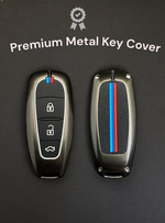 Two premium metal key covers with a brand logo on a dark background