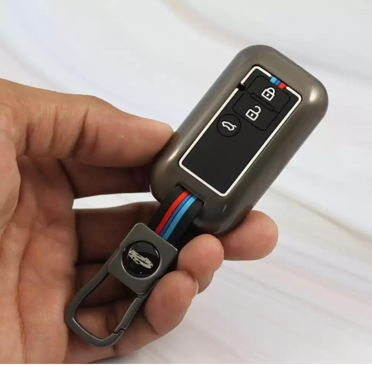 Hand holding a car key fob with buttons on a white background